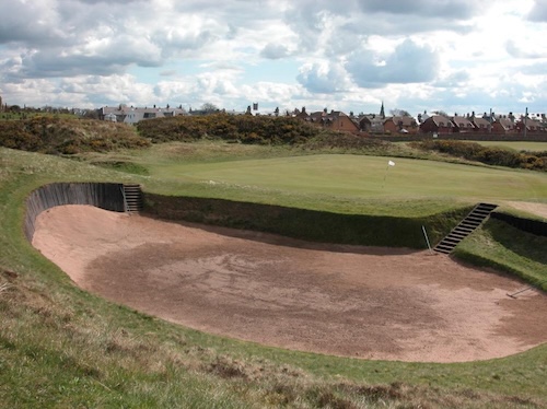 A deep revetted pot bunker with stacked turf walls