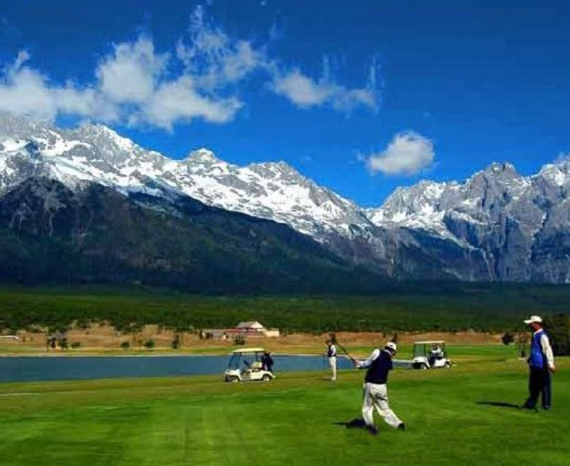 Jade Dragon Snow Mountain golf course with snow capped peaks behind